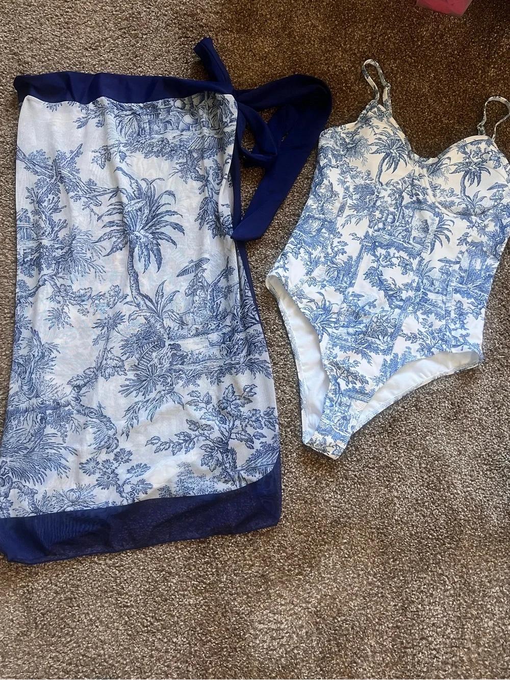 White and navy onepiece swimsuits with matching coverup.